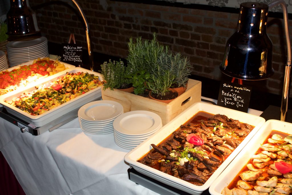 Warme Speisen aus Italien mit Kräutertöpfen dekoriert